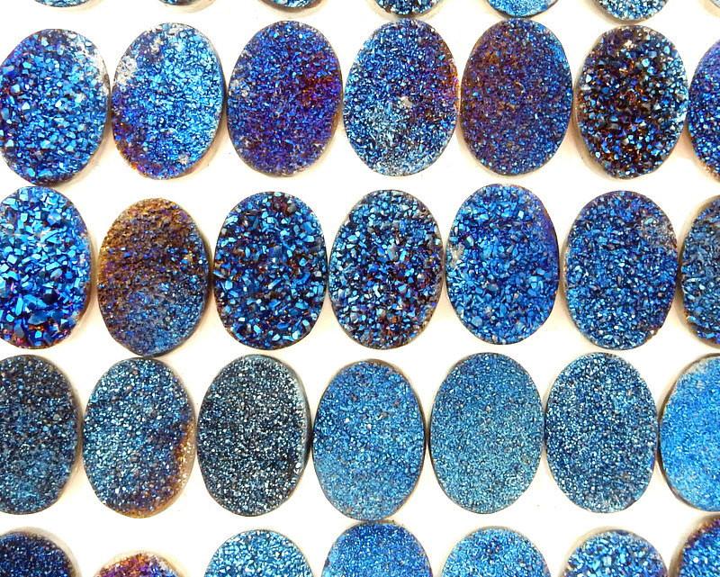 multiple Blue Oval Shaped Druzy Cabochons displayed on white background to show various characteristics such as textures formations color 