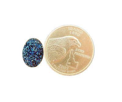 Blue druzy oval cabochon next to quarter for size reference 