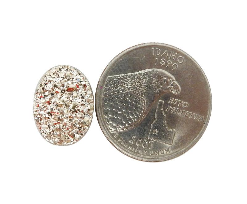 gold oval druzy cabochon next to a quarter for size reference on white background