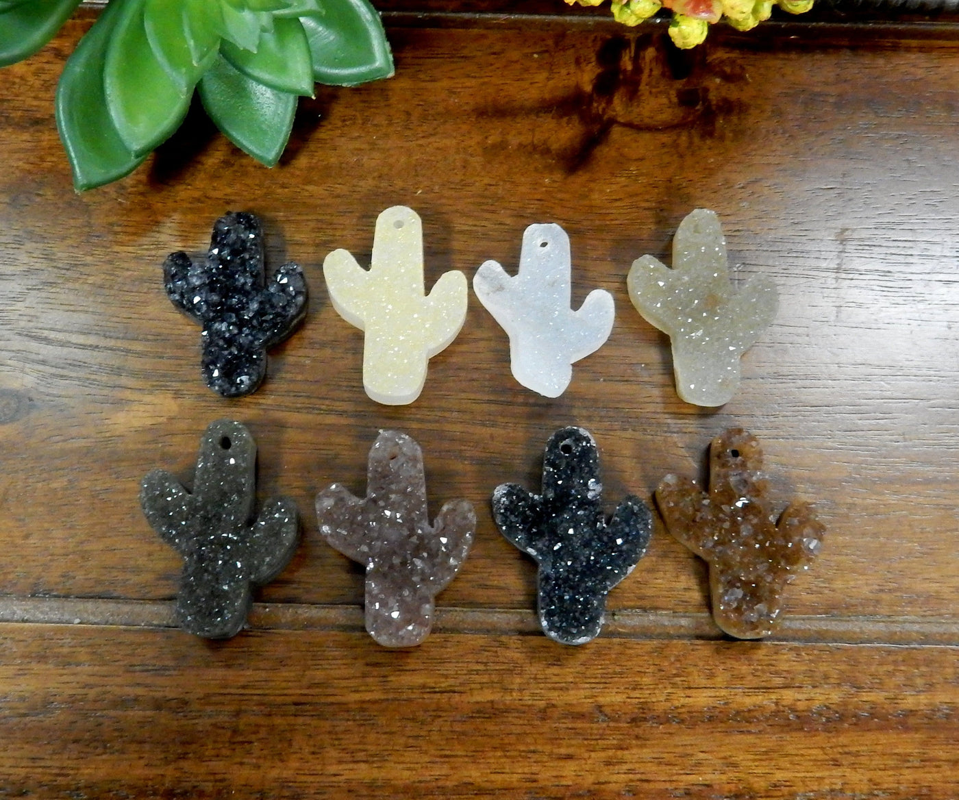 Assorted shades of quartz druzy cut into a cactus shape with a drilled hole on the top.  The colors they come in can be black, white, cream, tan, yellow, orange, purple, and black.