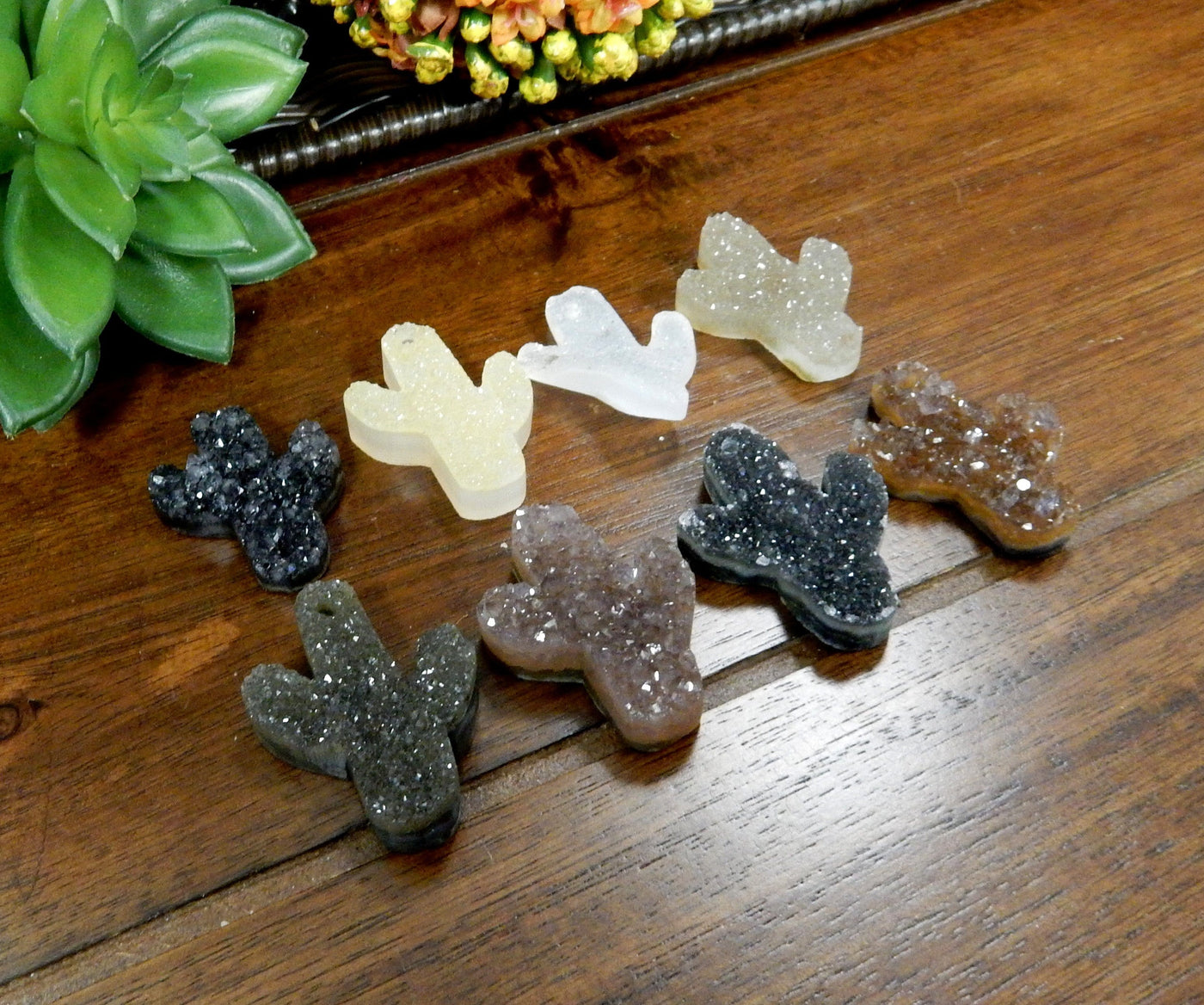 Assorted shades of quartz druzy cut into a cactus shape with a drilled hole on the top.  The colors they come in can be black, white, cream, tan, yellow, orange, purple, and black.