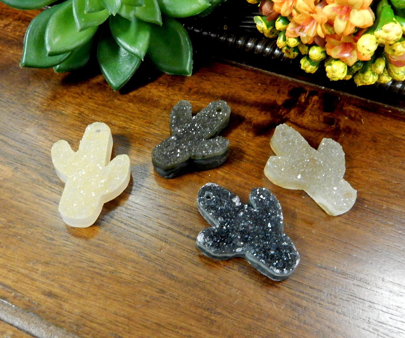 Assorted shades of quartz druzy cut into a cactus shape with a drilled hole on the top.  The colors they come in can be black, white, cream, tan, yellow, orange, purple, and black.