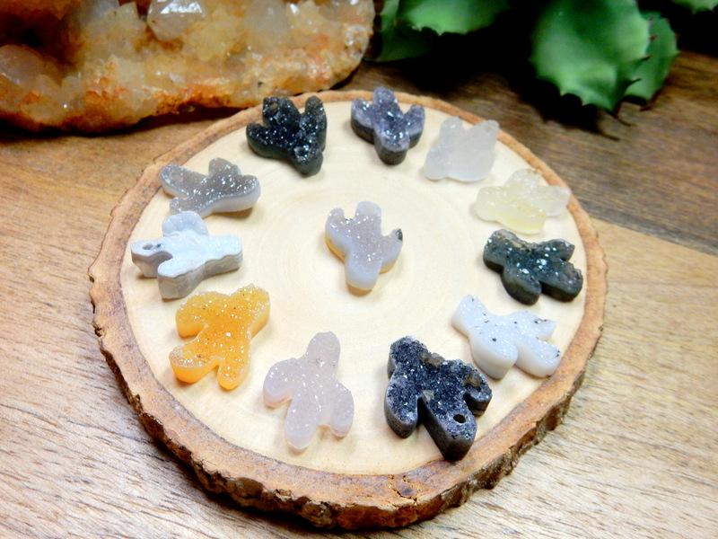 Assorted shades of quartz druzy cut into a cactus shape with a drilled hole on the top.  The colors they come in can be black, white, cream, tan, yellow, orange, purple, and black.