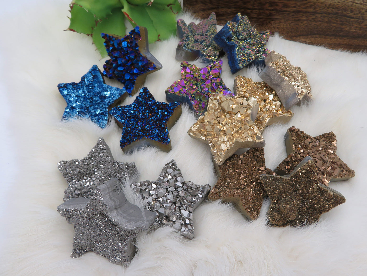 Fifteen Titanium Treated Druzy Stars displayed on a white fuzzy surface.