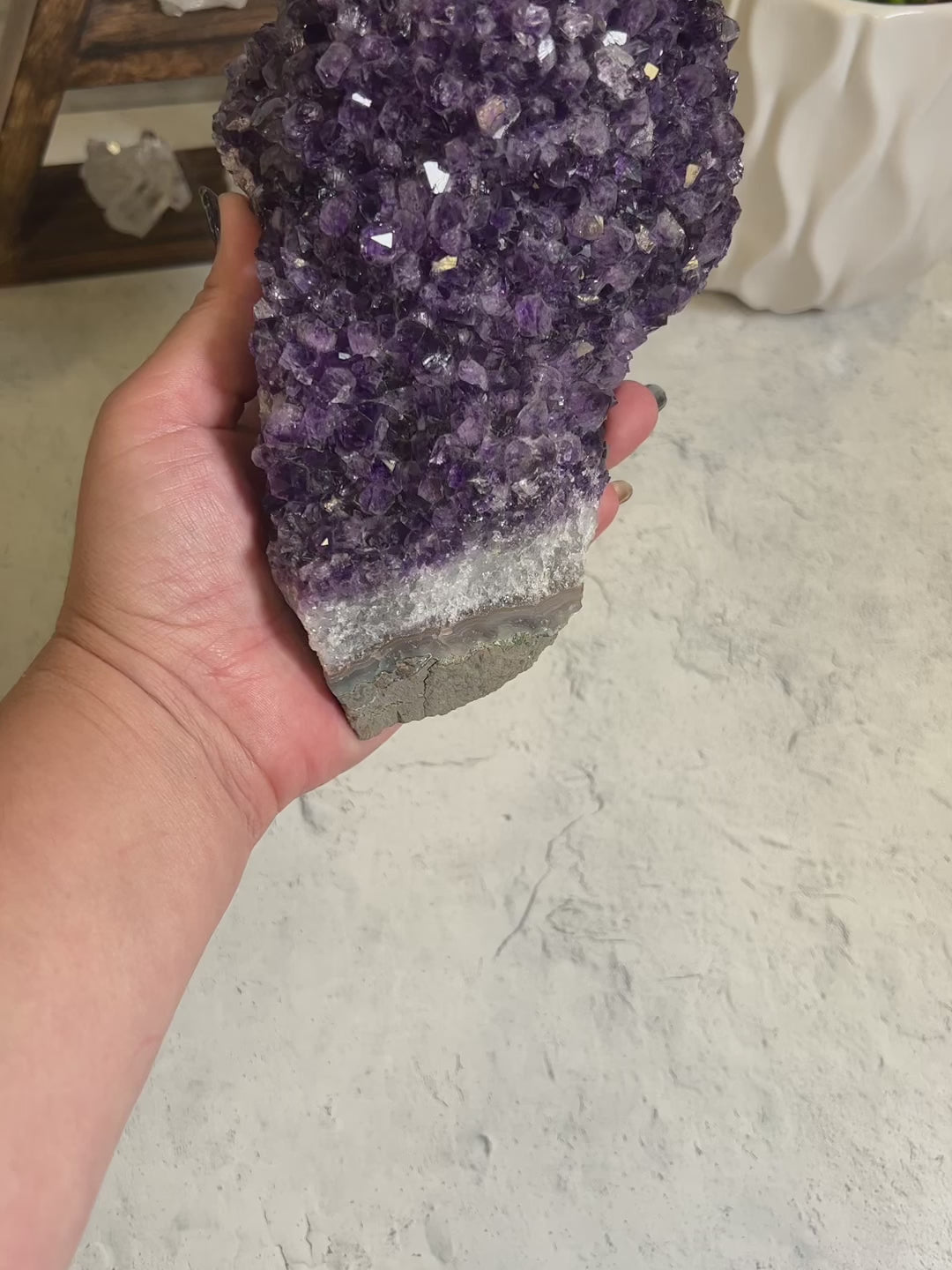 Video of large amethyst cluster with a woman holding it.