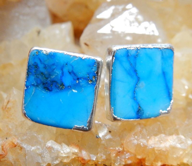 A pair of Gemstone Square Shaped Stud Earrings in Turquoise Howlite on top of a citrine cluster