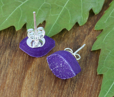 one pair of purple earrings on a table