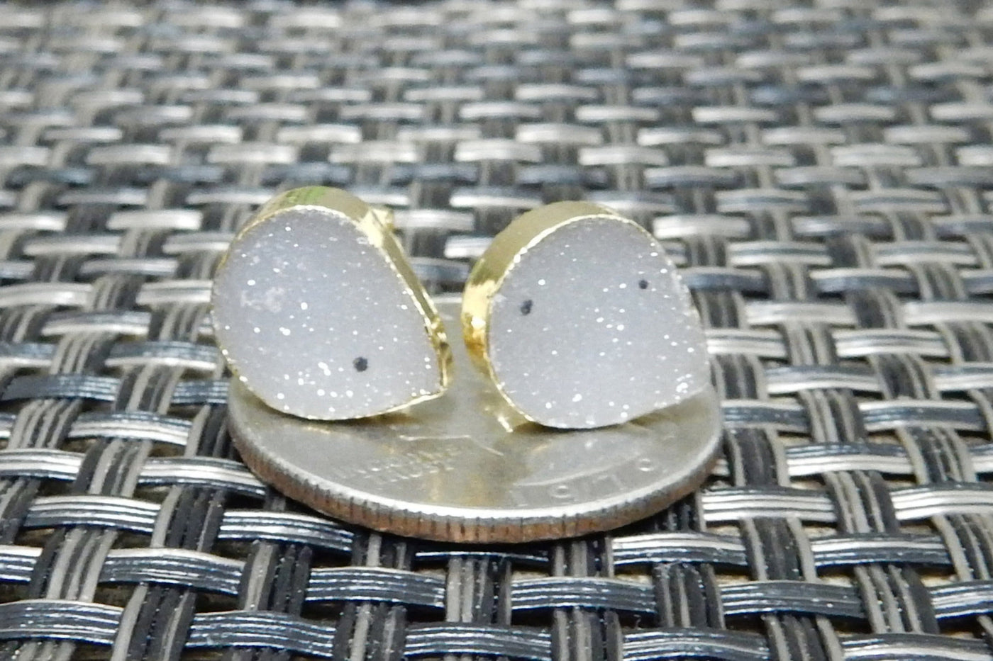 A teardrop Shape Druzy Stud Earring set on a quarter for sizing