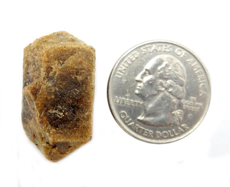 Epidote Stone next to a quarter on a white background.