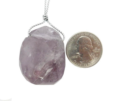 A Faceted Amethyst Bead Top Side Drilled Large Bead next to a quarter. 