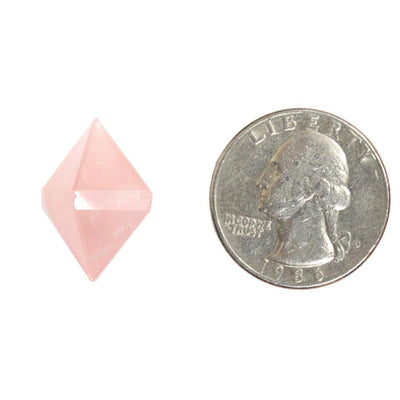 Rose Quartz Diamond Shaped Stone next to a quarter for size comparison on white background