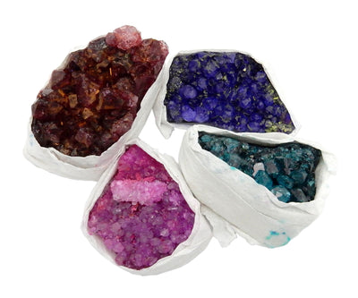 4 dyed amethyst pieces on a white background.  They are wrapped in protective white tissue on the sides.  Colors shown are red, blue, pink, and teal.