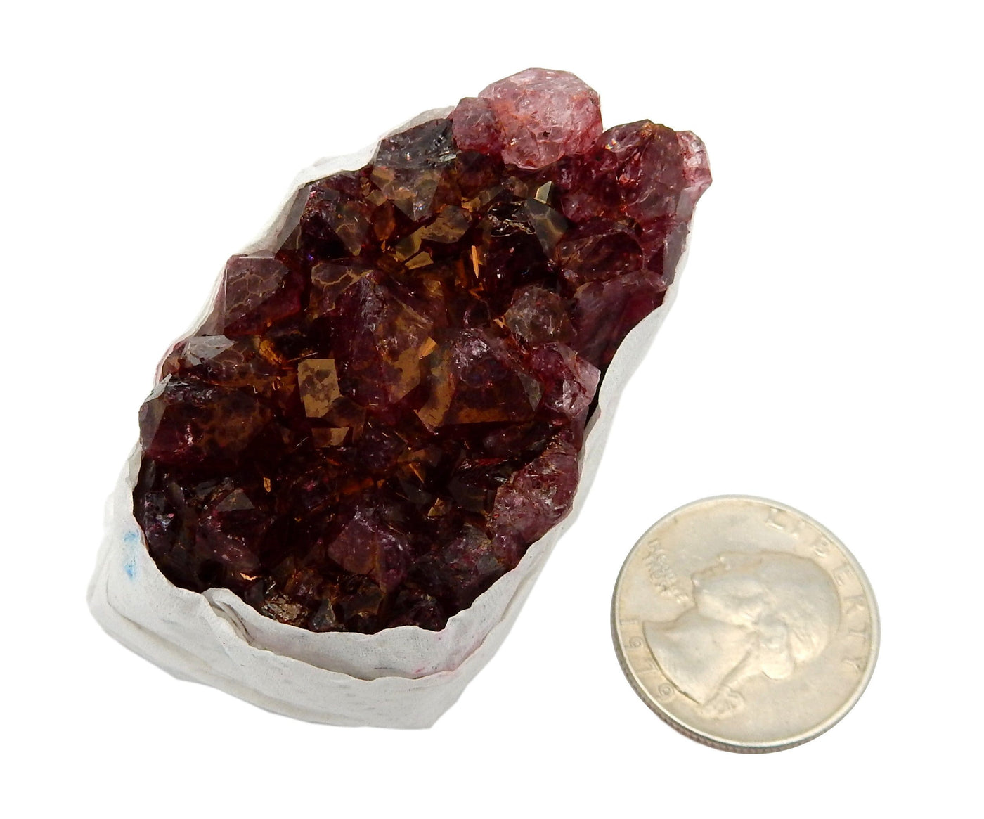 One dyed red amethyst druzy on a white background compared with a quarter. It is twice the size of the quarter.