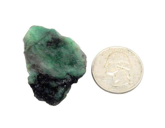 emerald chunk next to a quarter for size reference