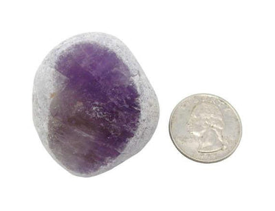 A amethyst Emma Egg Seer Stone next to a quarter on white background.