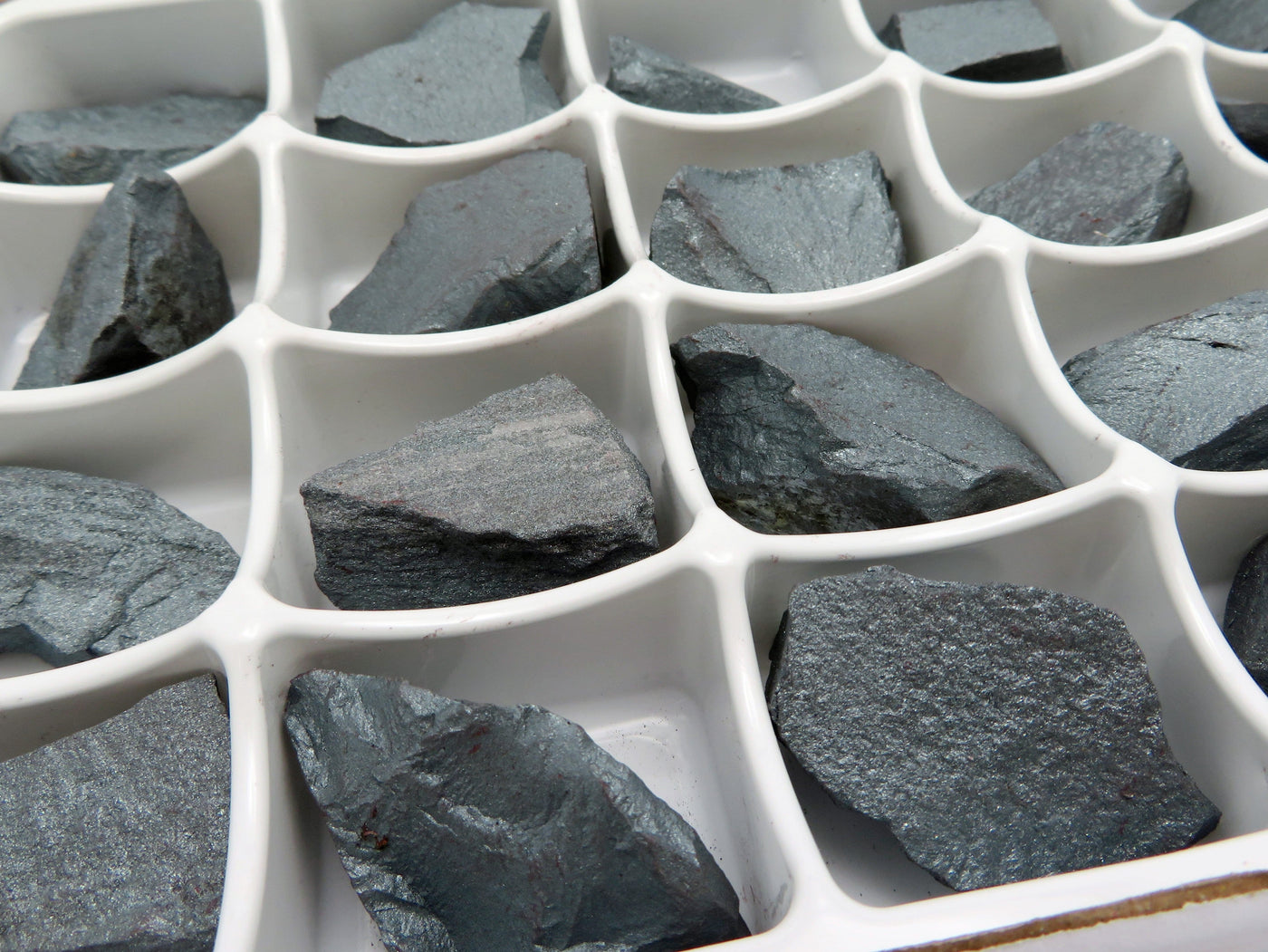 close up of hematite chunks in the box showing them at an angle to see different texture and design