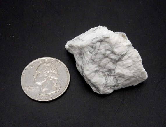 howlite chunk next to a quarter for size reference on black background