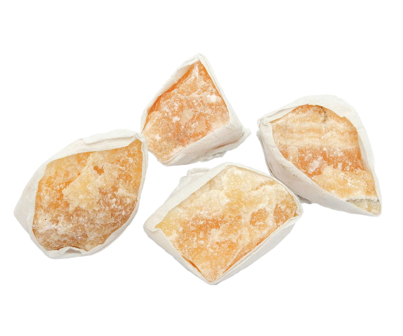 multiple pieces of orange calcite wrapped in tissue for packing 