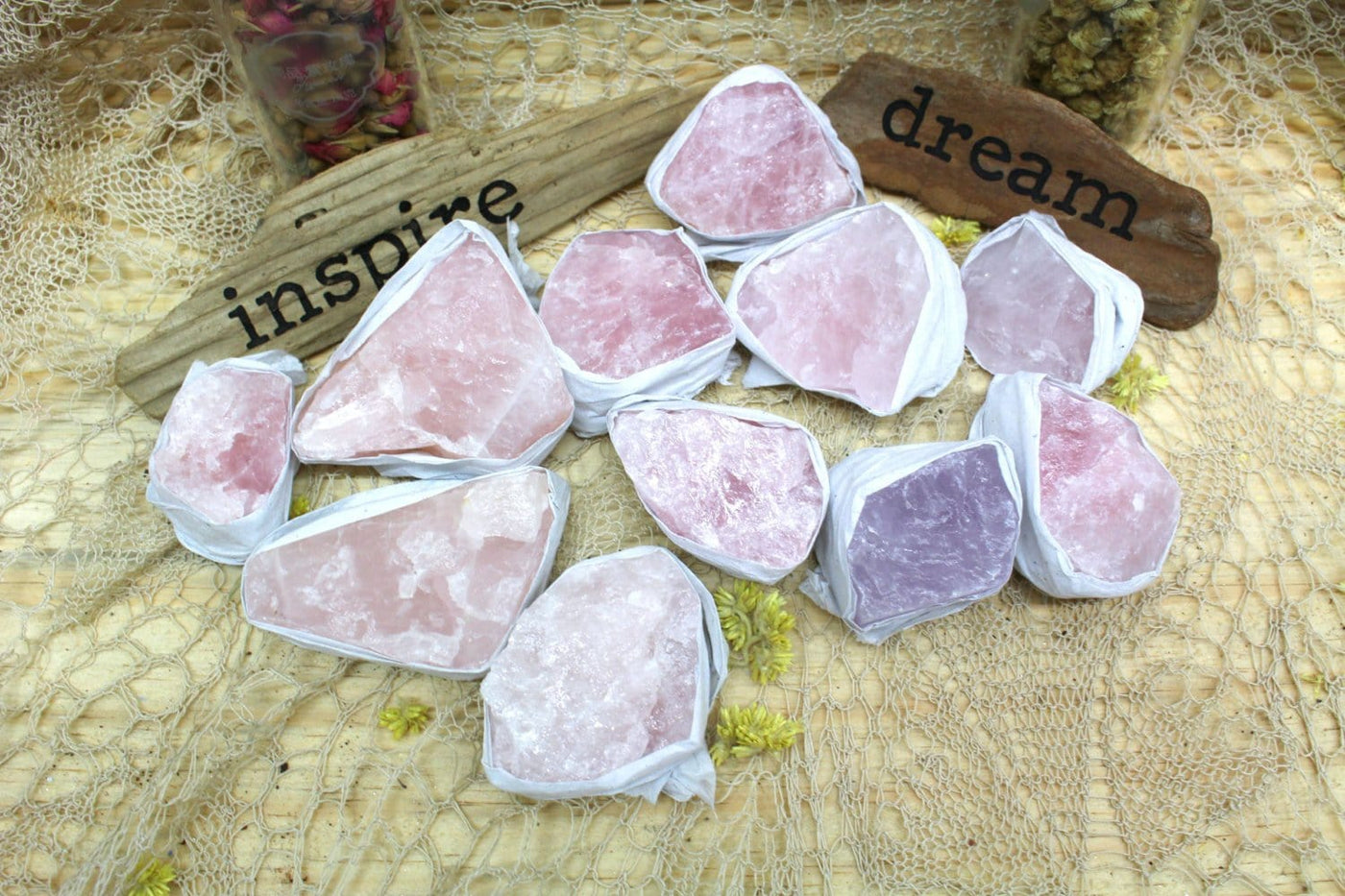 Rough Rose Quartz pieces on lacey background with "dream" and "inspire" signs