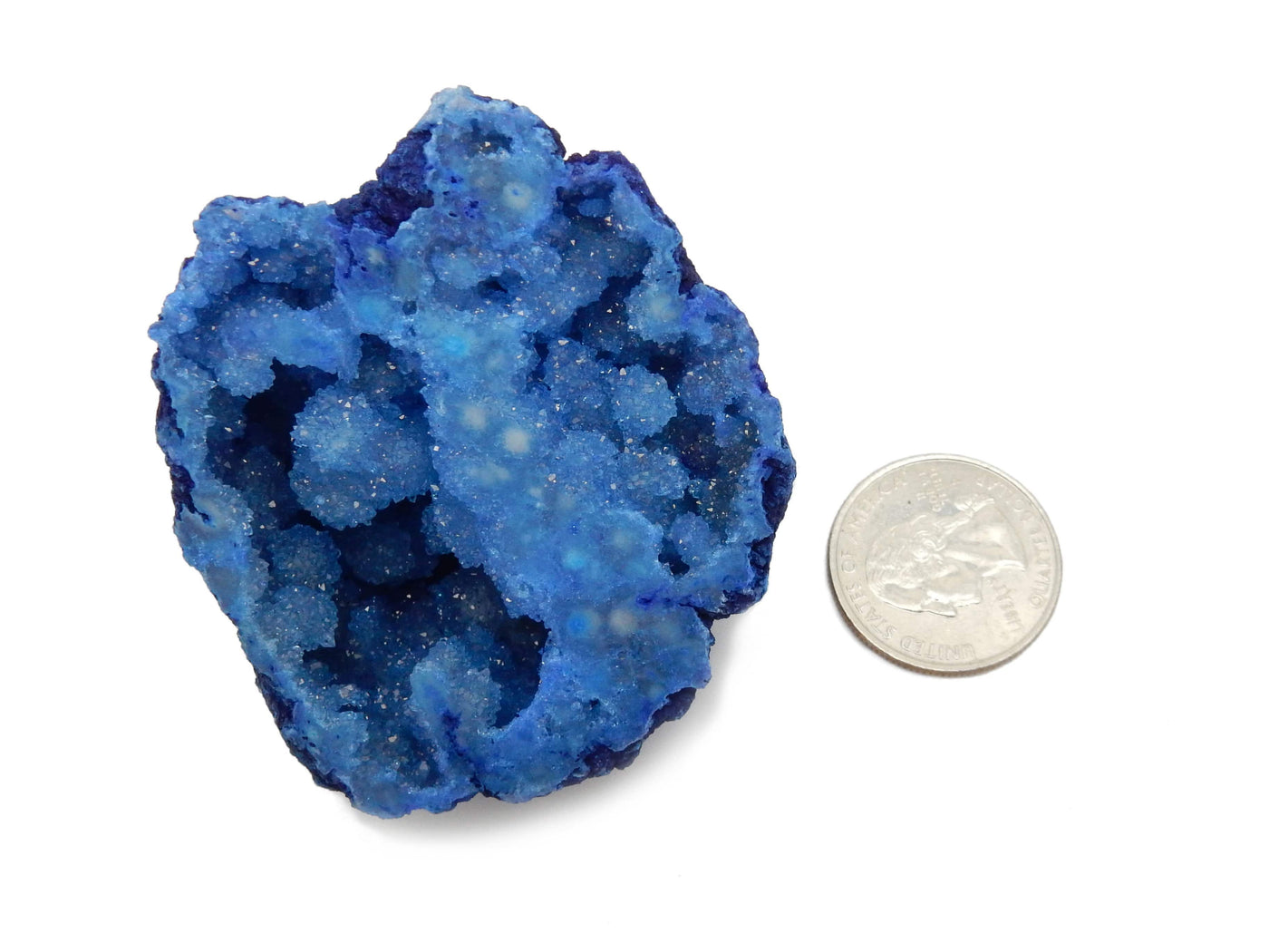 a Blue Large Geode Half next to a quarter for size