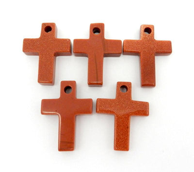 5 Goldstone red with sparkles cross on a white background.  It has a drilled hole on the top.