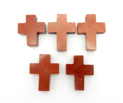 Goldstone Cross Pendant Charm, different tone colors on flat surface. 