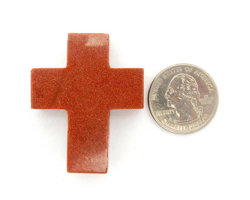 Goldstone Cross Pendant Charm compared with a quarter showing size reference. 