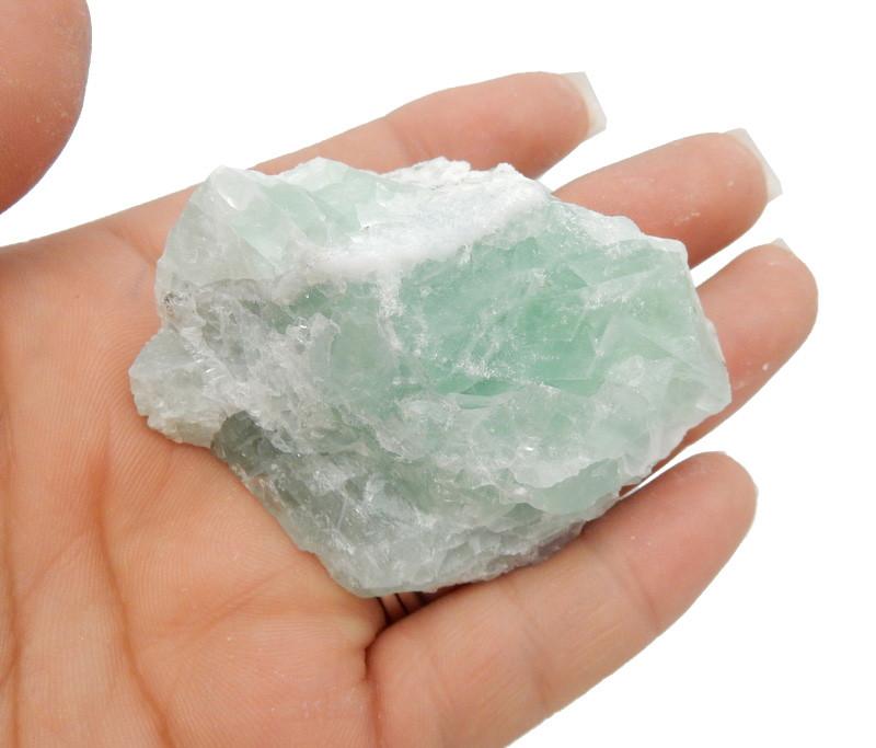 Green Fluorite crystal on hand for size comparison