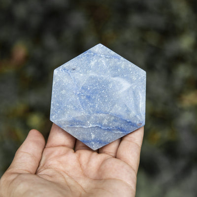 blue quartz hexagon in hand for size reference 