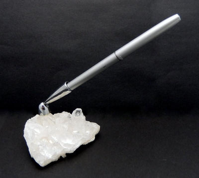 Crystal cluster pen holder with a silver pen on a black background.