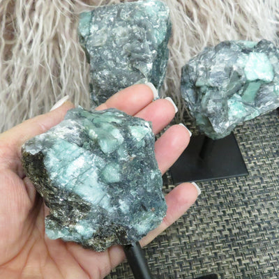 Emerald on Metal Stand - Raw Emerald Chunk on a hand.