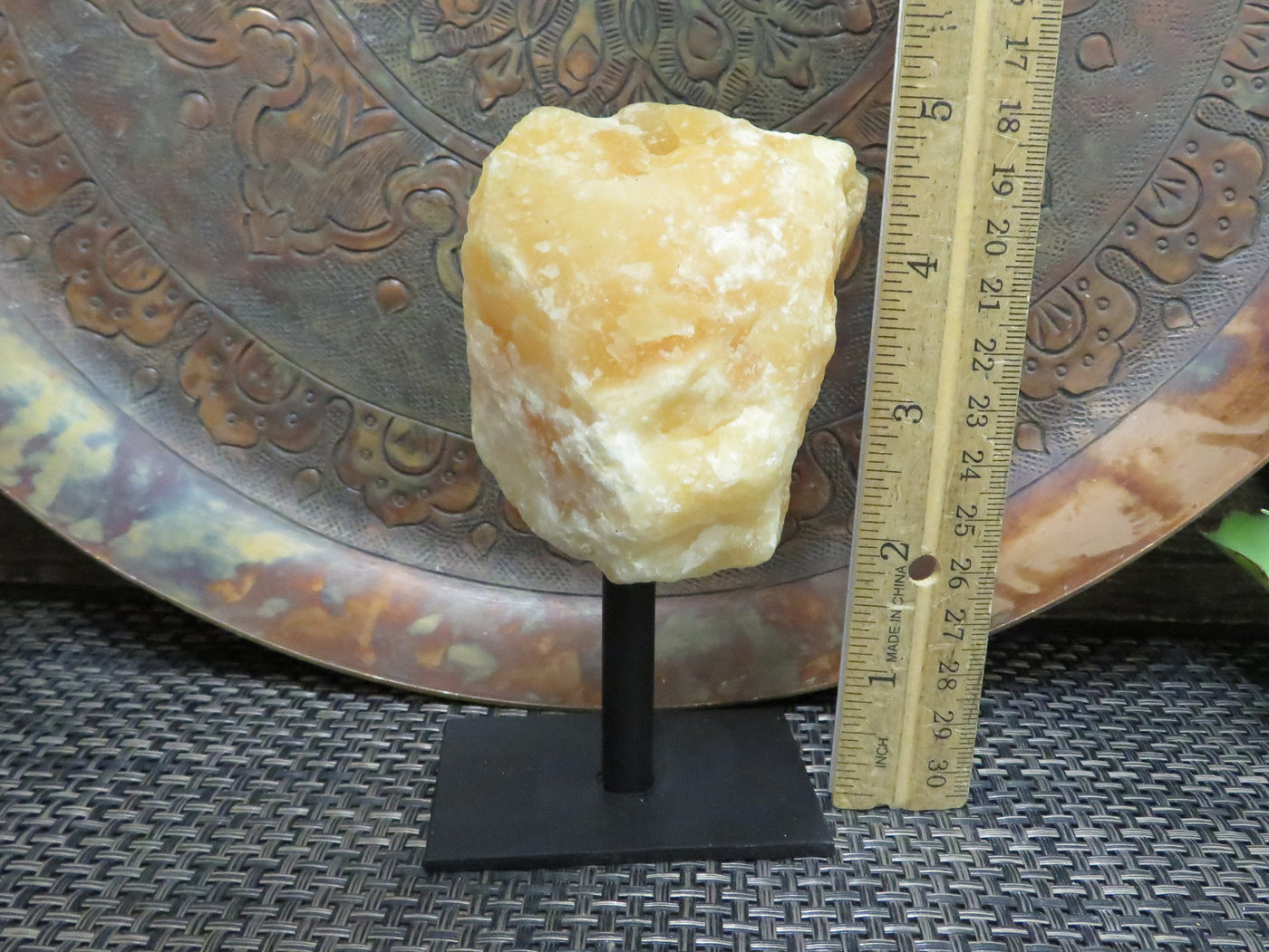 Products Orange Calcite on Metal Stand - next to a ruler
