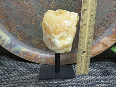 Products Orange Calcite on Metal Stand - next to a ruler