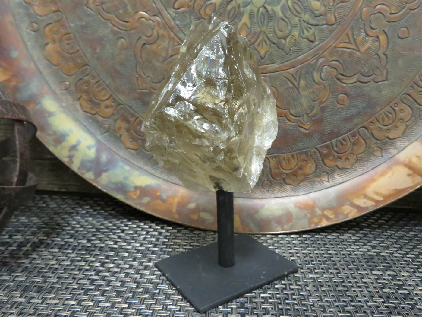 smoky quartz on metal stand with decorations in the background