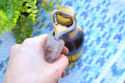 Natural Stone Bottle Opener - in a hand opening a bottle