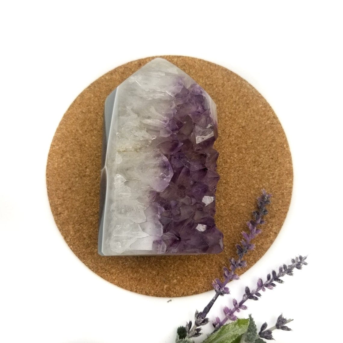 Amethyst Polished Geode Crystal Cut Base Cluster with decorations in the background