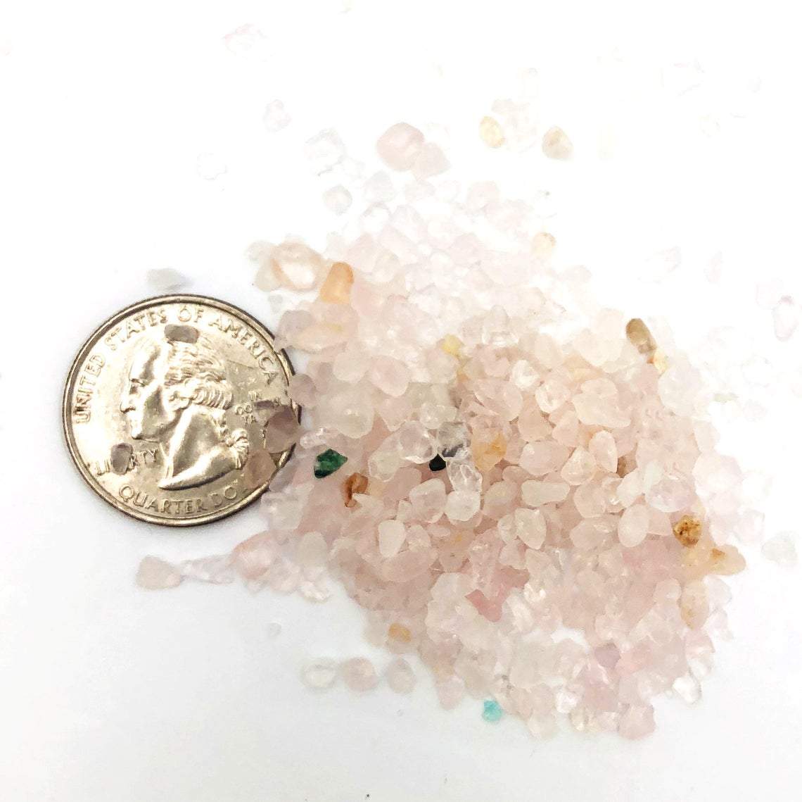 Small pile of Rose Quartz Tiny Chip Stones next to a quarter for size reference