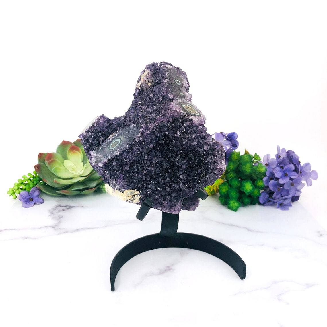 Amethyst Purple Geode Crystal With Stalactite on Metal Stand with decorations in the background