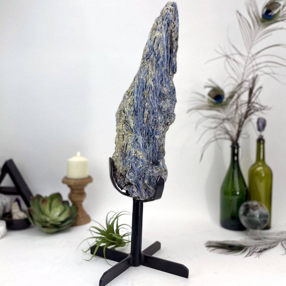 side view of Products Blue Kyanite on Metal Stand with decorations in the background