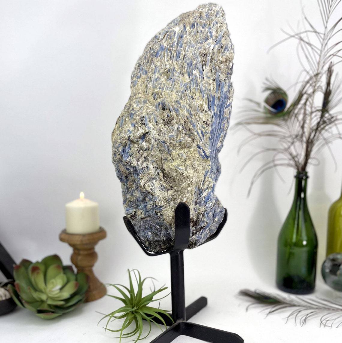 Products Blue Kyanite on Metal Stand with decorations in the background