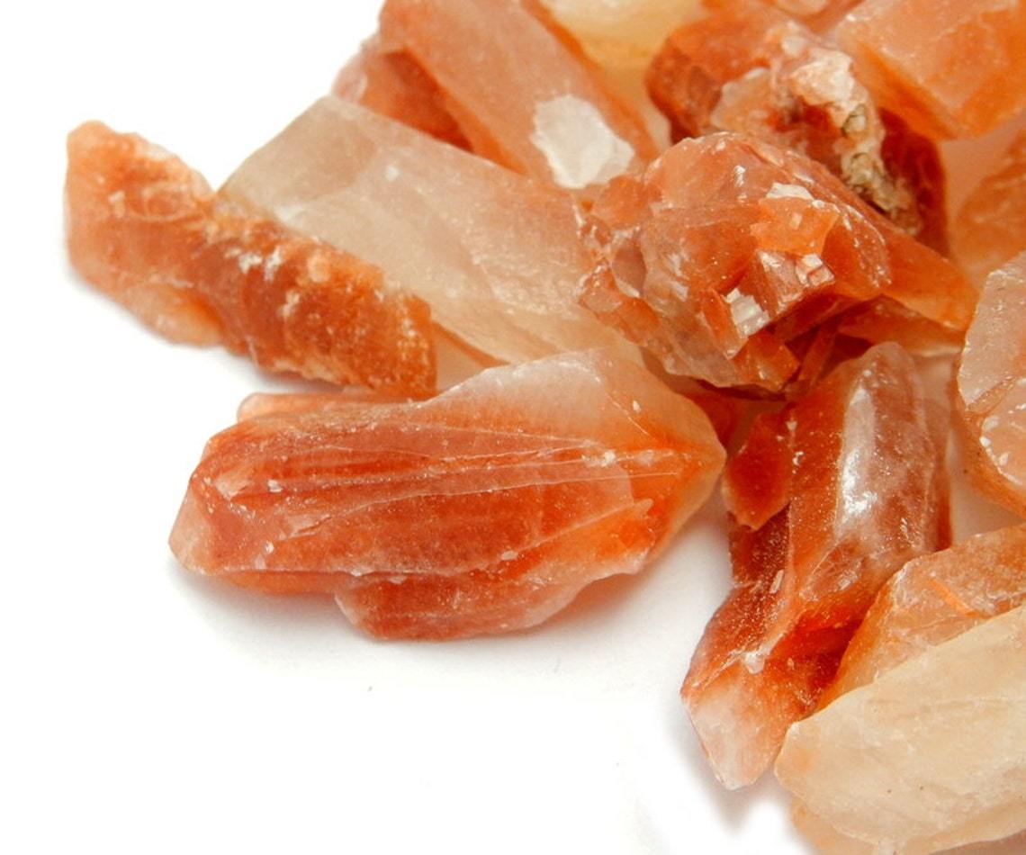 Up close shot of pile of Red Calcite Stones on white background