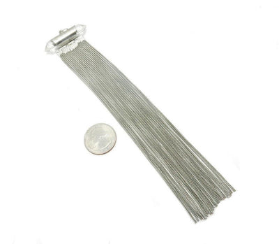 A Silver Toned Chain Double Terminated Crystal Quartz Tassel Pendant next to a quarter showing an approx. size