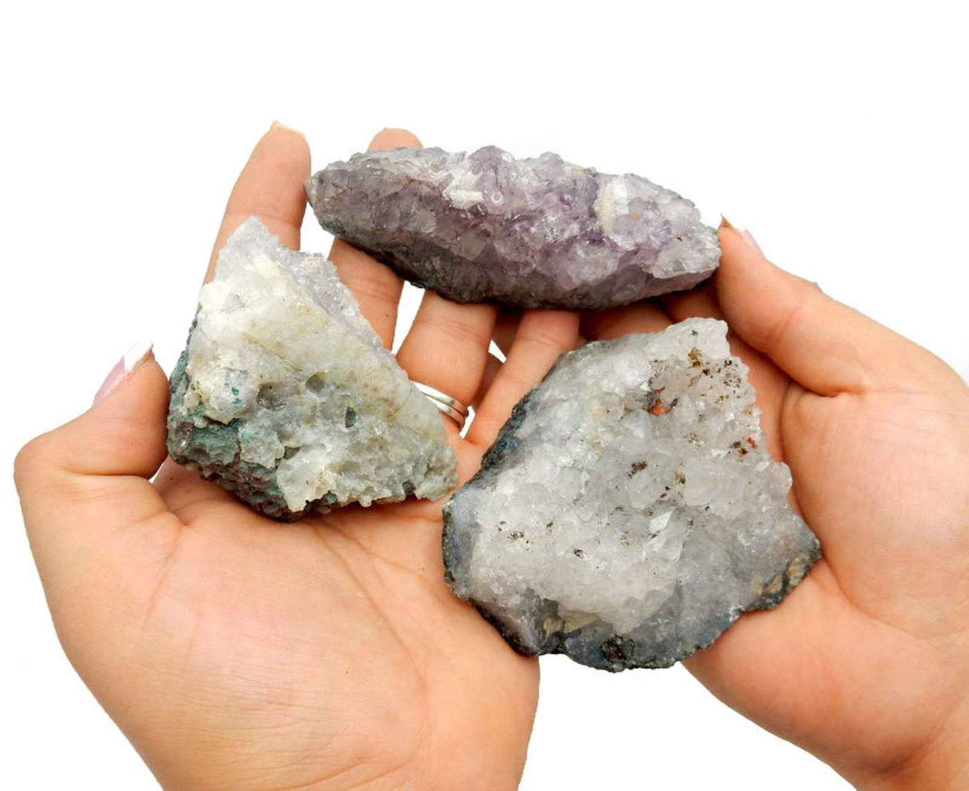 Picture of amethyst clusters being held for size reference. 
