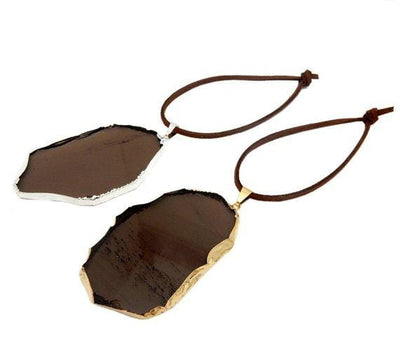 smokey quartz ornaments displayed in silver and gold with brown faux leather tie side view for thickness reference