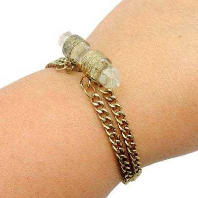 Double Terminated Crystal Quartz Point Bracelet with Brass Chain and Bands in Wrist on White Background.