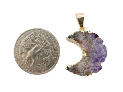 One Amethyst slice moons with gold plating around the edges and a gold bail on a white background next to a quarter.  It is about the same size as the quarter.