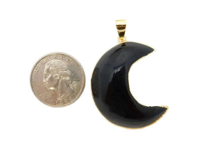 a black moon with gold finish next to a quarter for sizing