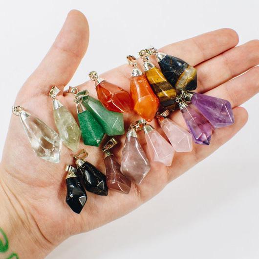 Gemstone Point Pendants with Electroplated Silver Cap and Bail on hand for size comparison, showing the different crystals this item comes in