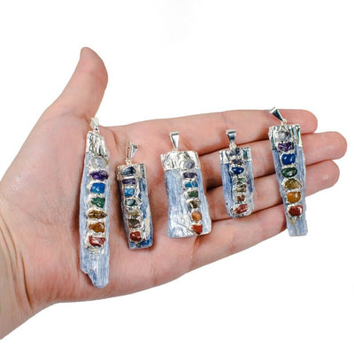 Raw Blue Kyanite Chakra Pendants Charms with silver plated finish in a hand for size reference
