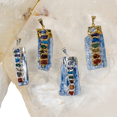 Raw Blue Kyanite Chakra Pendants Charms in silver and gold plated finish. These have small stones of the chakra colors stacked in a line horizontally and attached to the front of the kyanite. 